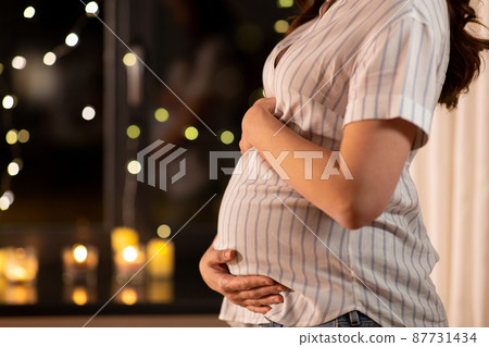 close up of pregnant woman at window at home close up of pregnant woman at window at home 87731434