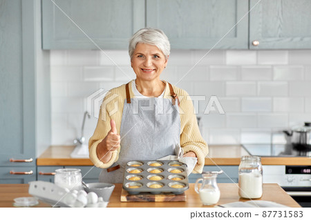 woman with cupcakes in baking mold on kitchen 87731583