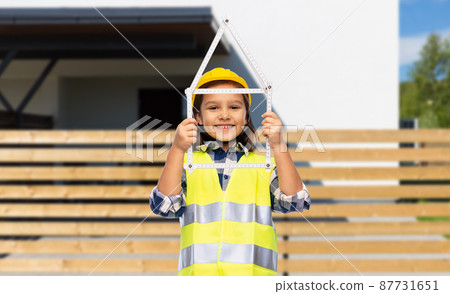 little girl in helmet with ruler in shape of house 87731651
