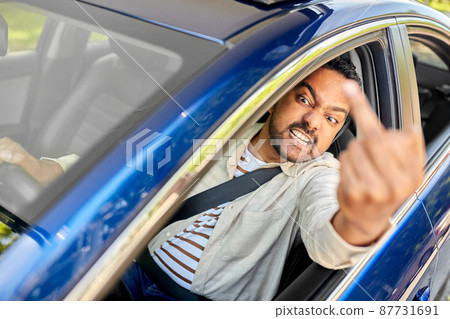 angry man driving car and showing middle finger 87731691
