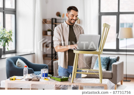 man with laptop preparing old chair for renovation 87731756