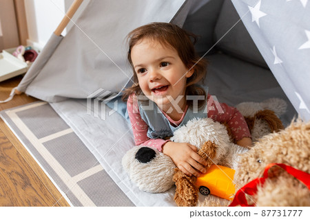 baby girl playing with toys in or teepee at home 87731777