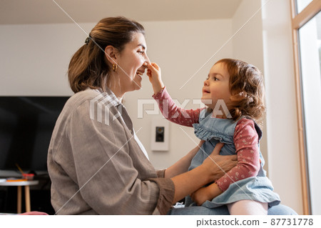 happy mother and daughter playing at home 87731778