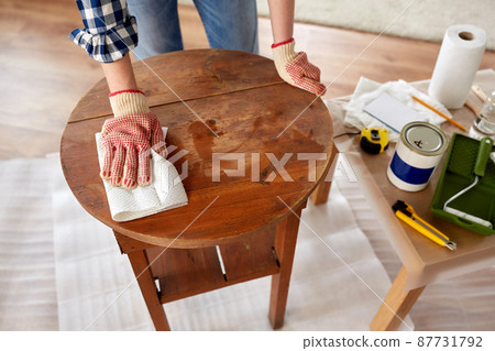 woman cleaning old table surface with paper tissue 87731792