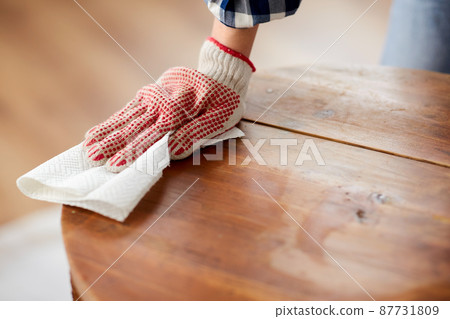 woman cleaning old table surface with paper tissue 87731809