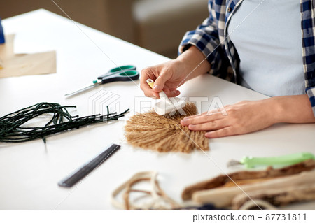 woman with brush making macrame on table at home woman with brush making macrame on table at home 87731811