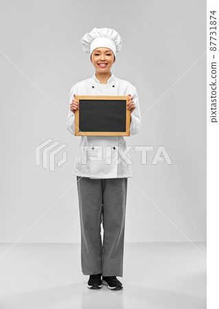 smiling female chef holding black chalkboard smiling female chef holding black chalkboard 87731874