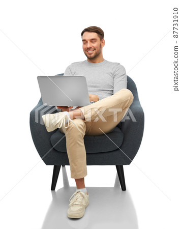 smiling man with laptop sitting in chair smiling man with laptop sitting in chair 87731910