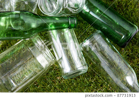 close up of empty glass bottles and jars on grass 87731913
