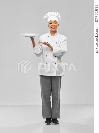 happy smiling female chef holding empty plate happy smiling female chef holding empty plate 87731952