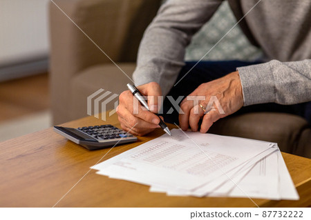 senior man with bills and calculator at home senior man with bills and calculator at home 87732222