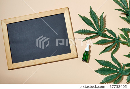 hemp essential oil, chalkboard and cannabis leaves 87732405