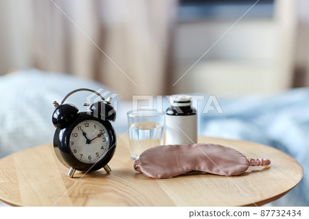 alarm clock, mask and sleeping pills on table alarm clock, mask and sleeping pills on table 87732434