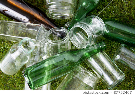 close up of empty glass bottles and jars on grass close up of empty glass bottles and jars on grass 87732467
