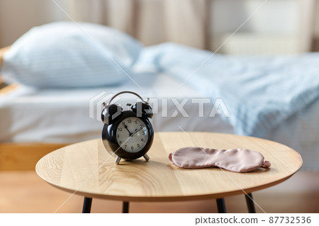 alarm clock and eye sleeping mask on table at home alarm clock and eye sleeping mask on table at home 87732536