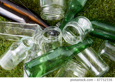 close up of empty glass bottles and jars on grass 87732556