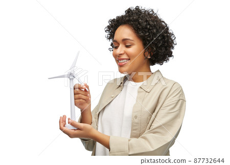 happy woman holding toy wind turbine happy woman holding toy wind turbine 87732644