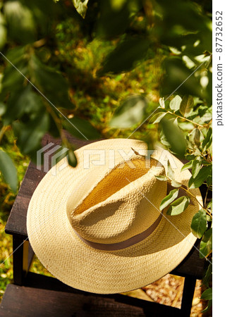 close up of straw hat on stool at summer garden close up of straw hat on stool at summer garden 87732652