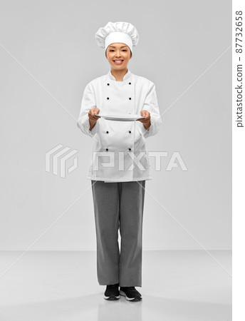 happy smiling female chef holding empty plate happy smiling female chef holding empty plate 87732658