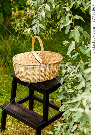close up of picnic basket on stool in garden close up of picnic basket on stool in garden 87732667