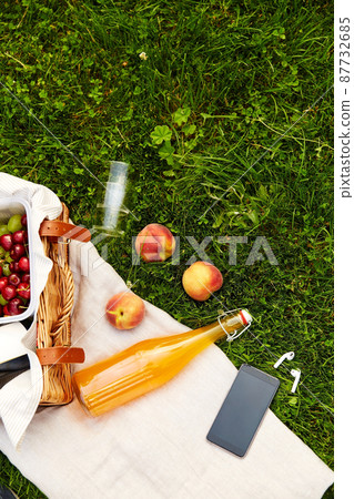 picnic basket, juice bottle, phone and earphones 87732685