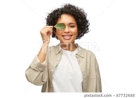 smiling woman holding green leaf smiling woman holding green leaf 87732688