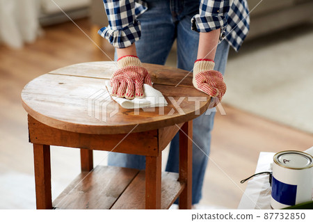 woman cleaning old table surface with paper tissue 87732850