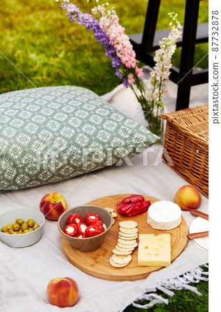 food, snacks and picnic basket on blanket on grass 87732878