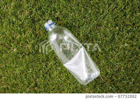 close up of empty used plastic bottle on grass 87732882