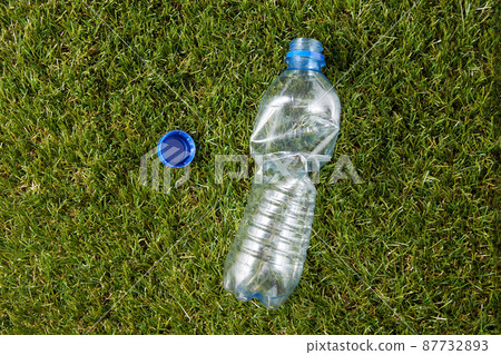 close up of empty used plastic bottle on grass 87732893