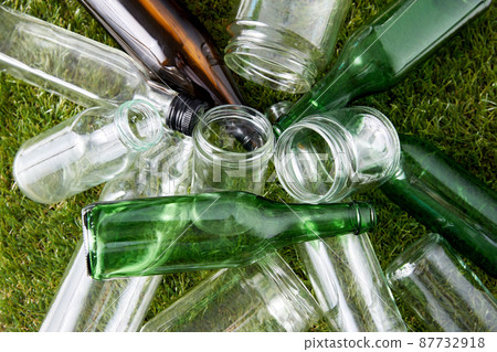 close up of empty glass bottles and jars on grass 87732918