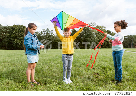 happy kids with kite playing at park 87732924