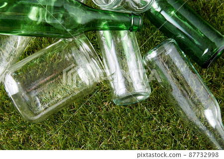 close up of empty glass bottles and jars on grass 87732998