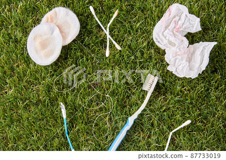 close up of used garbage on grass 87733019