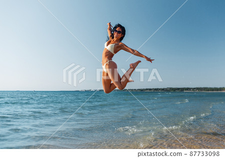 smiling young woman in bikini swimsuit on beach smiling young woman in bikini swimsuit on beach 87733098