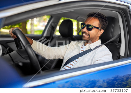 smiling indian man in sunglasses driving car smiling indian man in sunglasses driving car 87733107