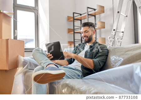 man with tablet pc and boxes moving into new home man with tablet pc and boxes moving into new home 87733108