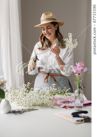 happy woman making bunch of flowers at home happy woman making bunch of flowers at home 87733390