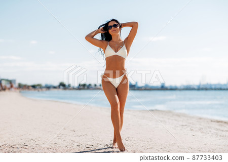 smiling young woman in bikini swimsuit on beach smiling young woman in bikini swimsuit on beach 87733403