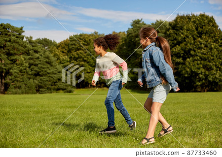 happy girls playing and running at park 87733460