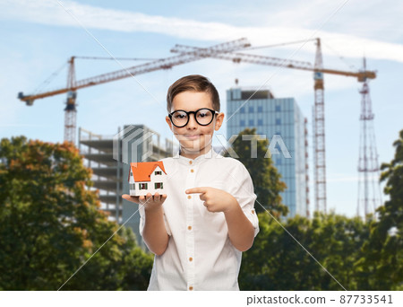boy in glasses with toy house at construction site boy in glasses with toy house at construction site 87733541