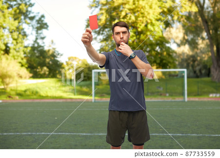 soccer referee whistling and showing red card soccer referee whistling and showing red card 87733559