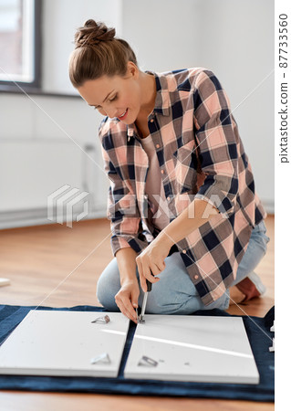 woman assembling furniture at home woman assembling furniture at home 87733560