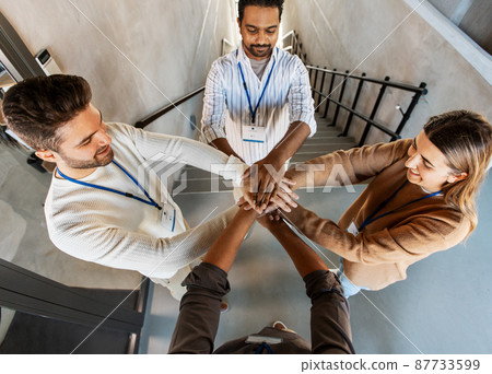 group of business people stacking hands at office 87733599