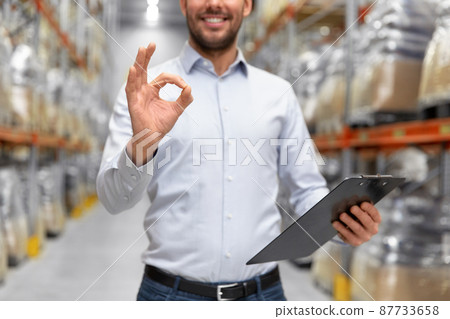 businessman with clipboard at warehouse showing ok businessman with clipboard at warehouse showing ok 87733658