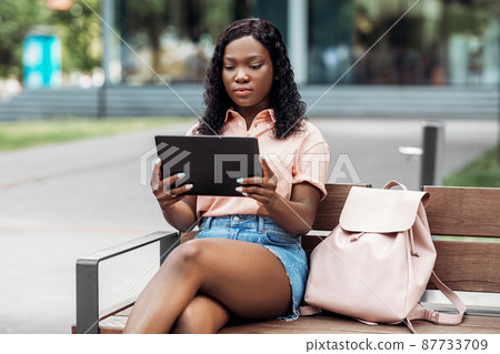 african american woman with tablet pc in city 87733709