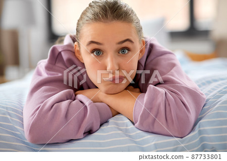 girl lying on bed at home and making face 87733801
