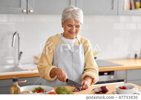 happy woman chopping red onion on kitchen happy woman chopping red onion on kitchen 87733830