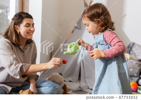 mother and daughter playing tea party at home 87733832