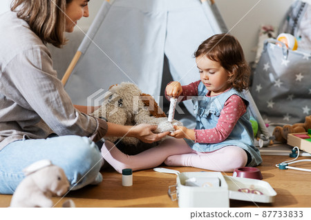 mother and daughter playing doctor at home mother and daughter playing doctor at home 87733833